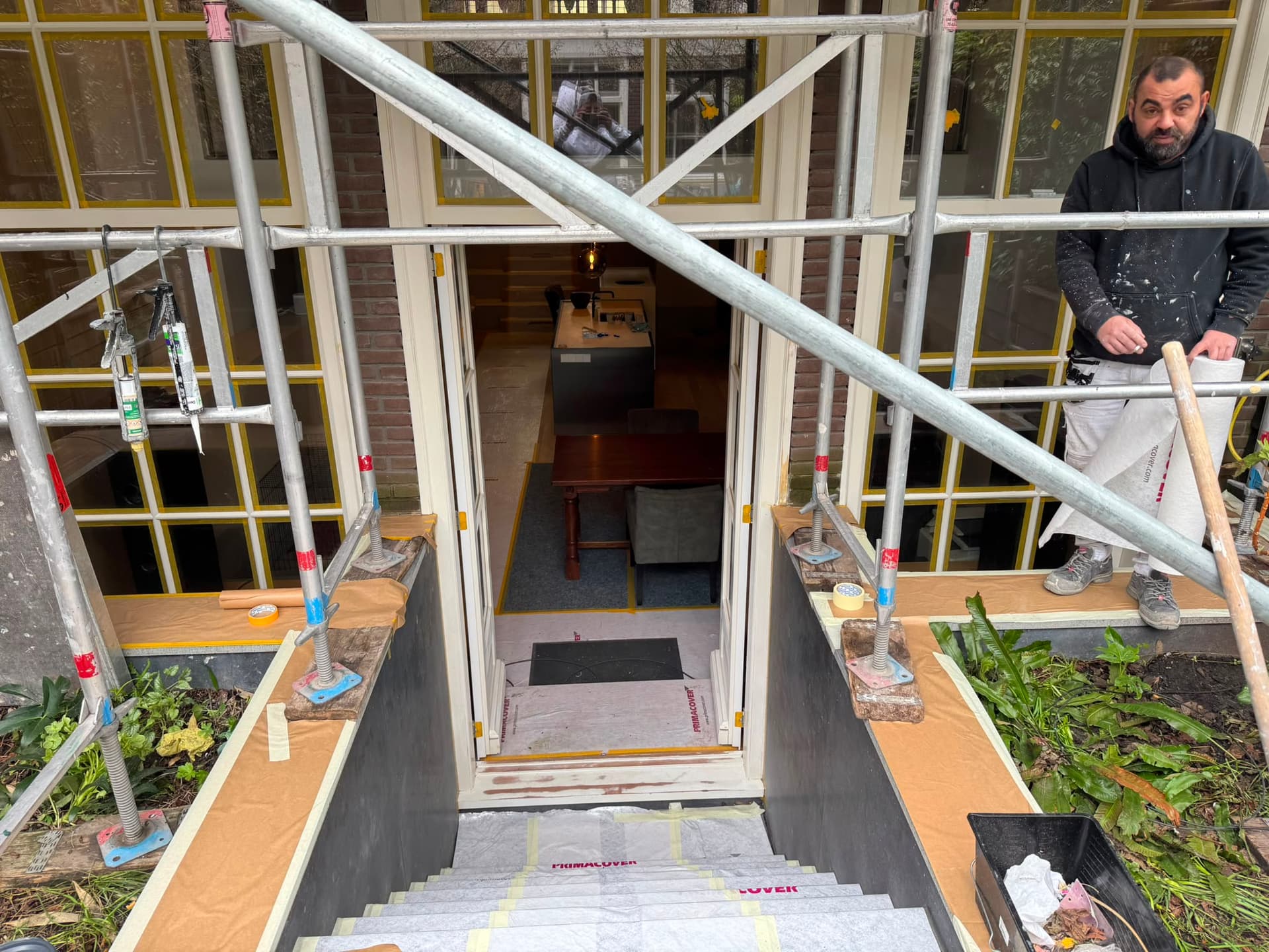 Schilderwerk aan tuindeuren met steiger op de achtergrond