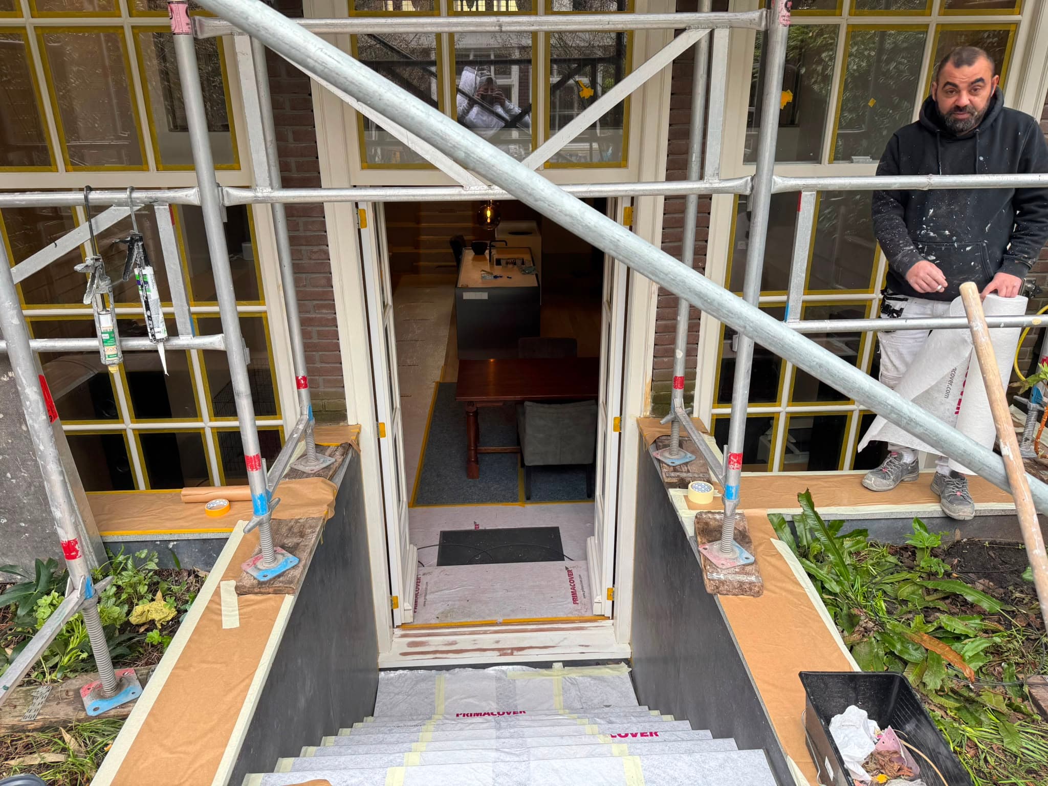 Schilderwerk aan tuindeuren met steiger op de achtergrond